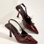 صنادل عالية الكعب بلون البرجندي الجذابة، بطرف حاد وأحزمة متقاطعة وإبزيمات بنعل ستيليتو، مثالية لحفلات الزفاف